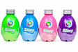 Four plastic bottles filled with colorful slimy substances in green, blue, pink, and purple, arranged in a row on a white background. Each bottle has a silver screw cap and a round sticker that reads 'Slimy DIY slime'.