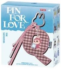 A boxed craft kit labeled 'PIN FOR LOVE' with a pink plaid keychain-style pin and small character figure shown on the front of the package.